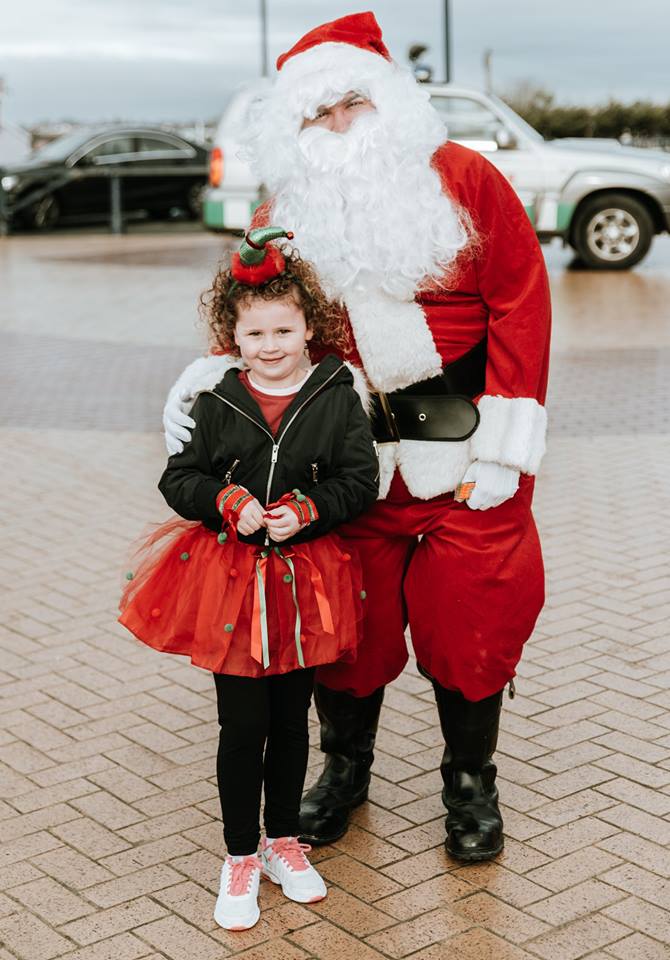 Little girl take photo with Santa Claus.