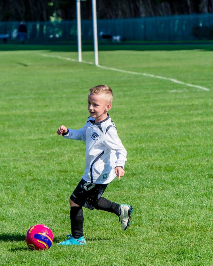 Little kid playing football.