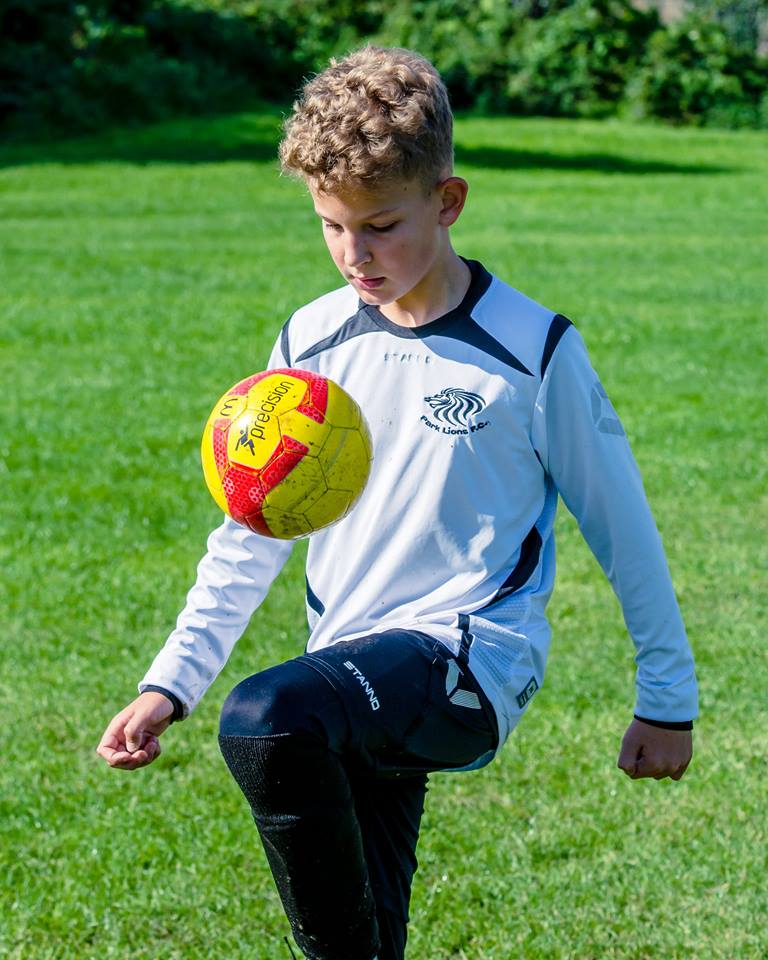 Kid hitting the ball.