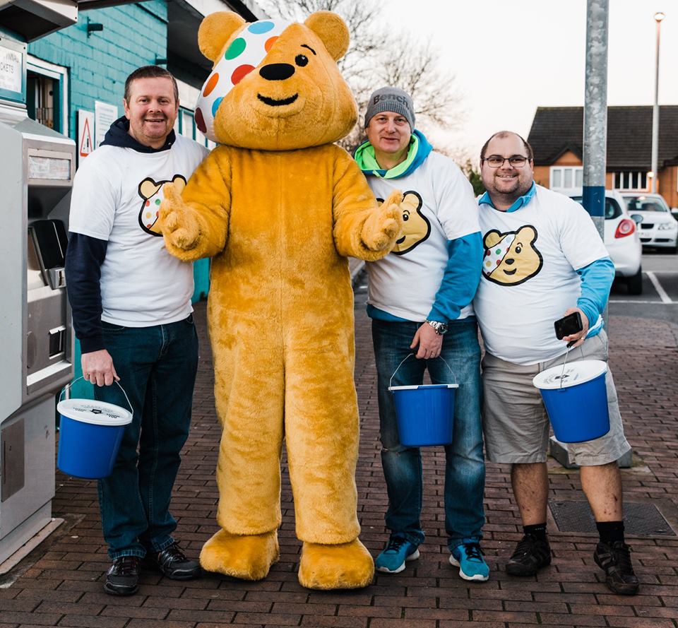 Pudsey Bear and three men.