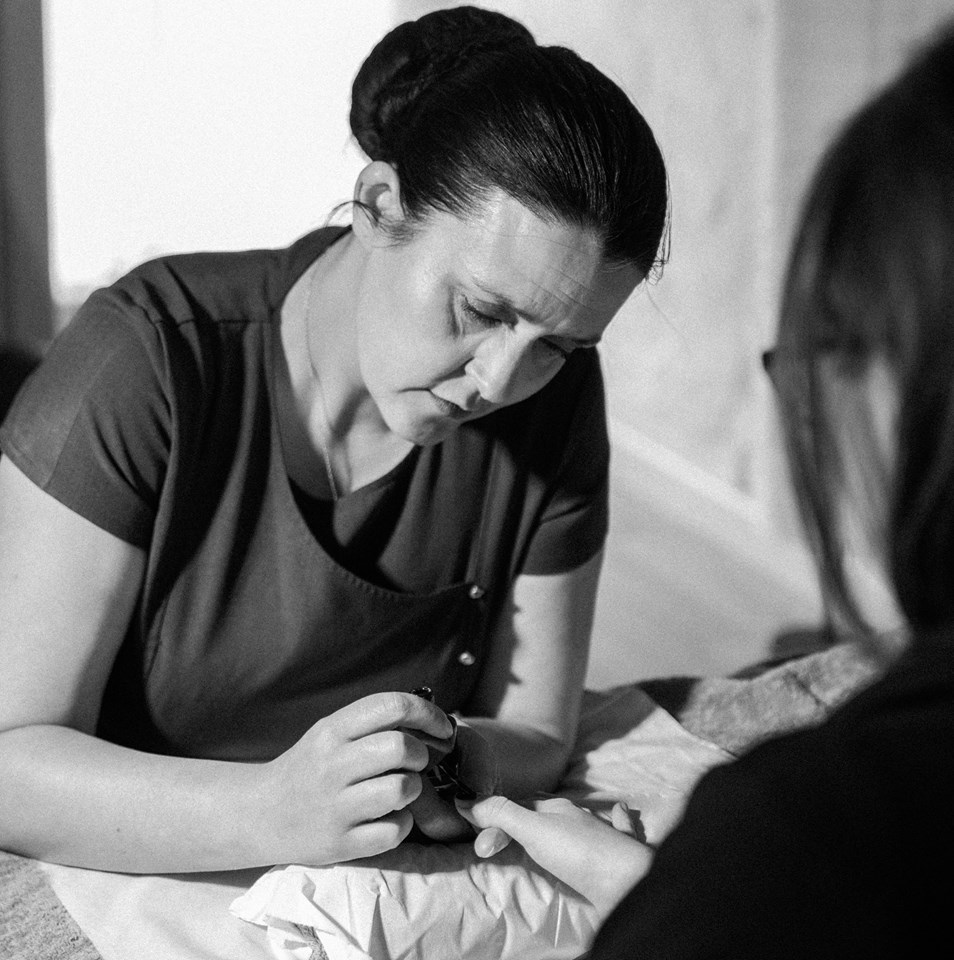 Oriel painting nails to her costumer.