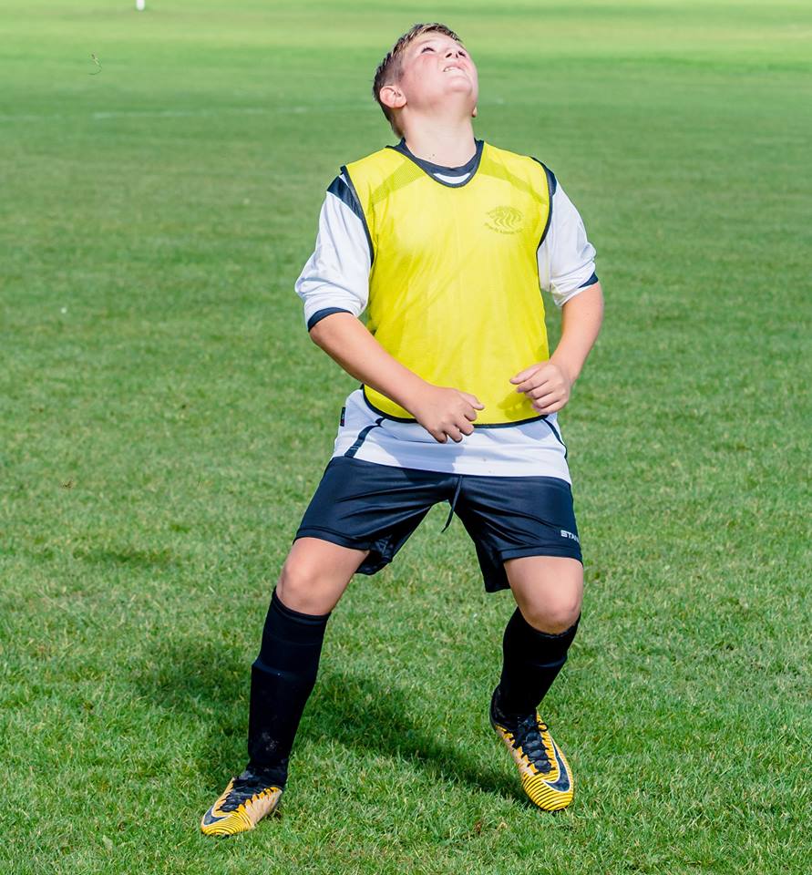 Kid player looking at the ball.