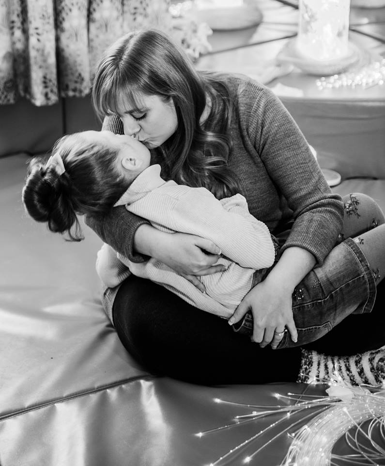 Laura Mellens giving a kiss to her daughter Blisse.